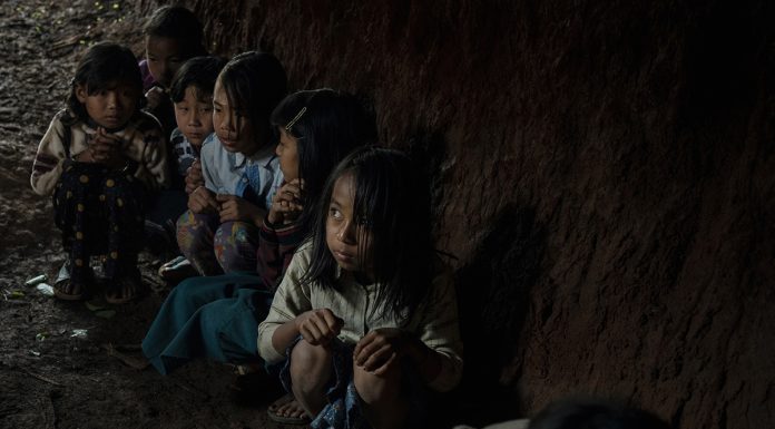 Children hide in their school bomb shelter during an emergency drill in case of mortar shelling