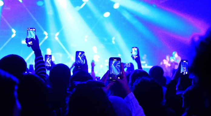 Personas haciendo fotos en un conierto – Portada © Lobar Qudratovna