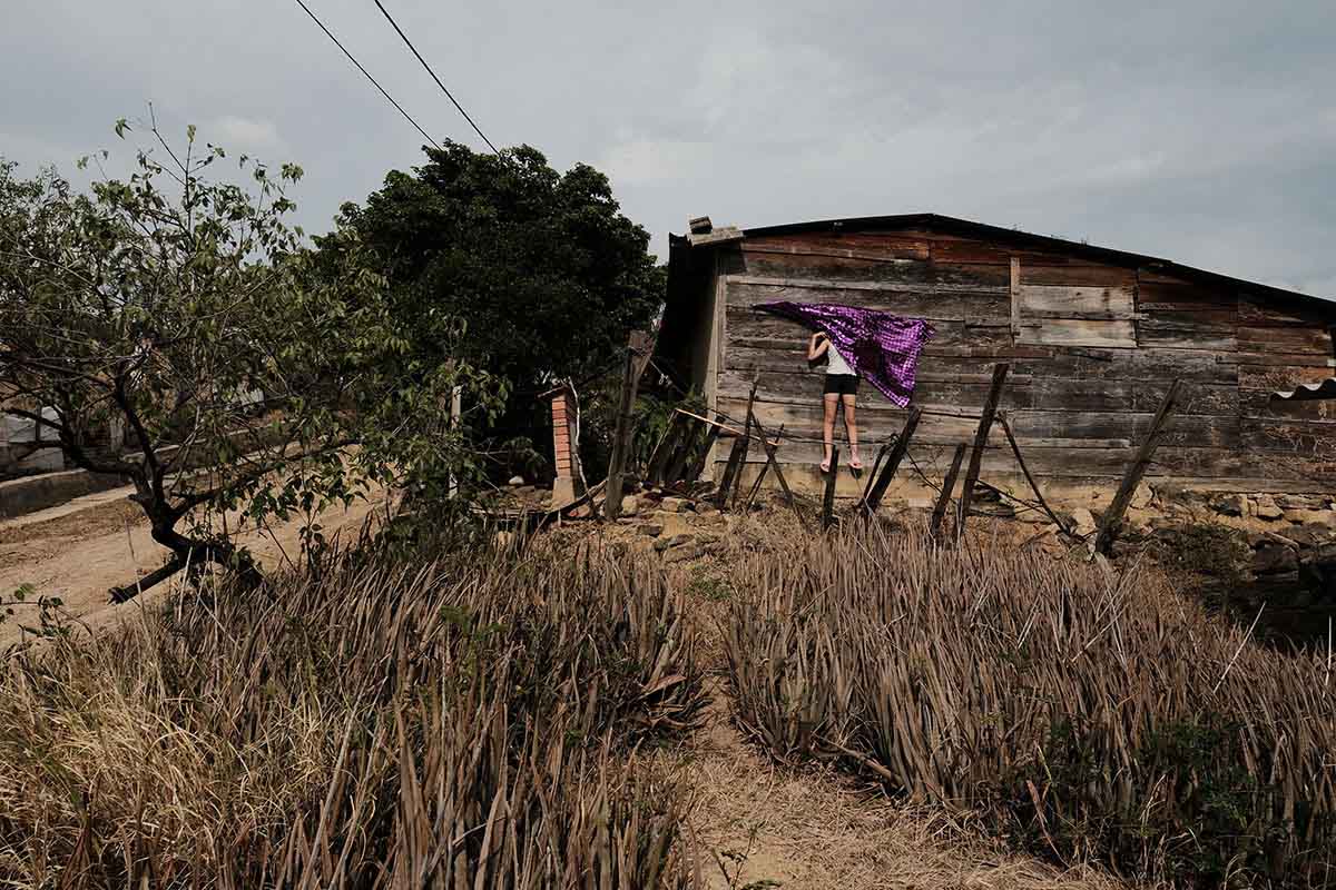 Gabriela (12) hides behind a cloth on the wall of her grandmothe